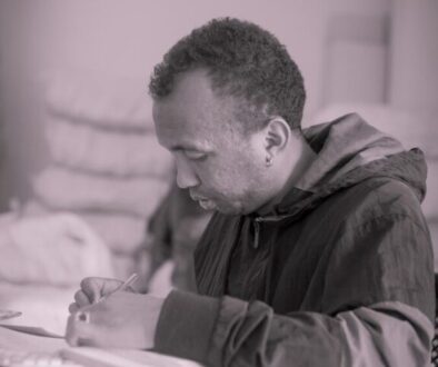 a man sitting at a desk writing on a piece of paper