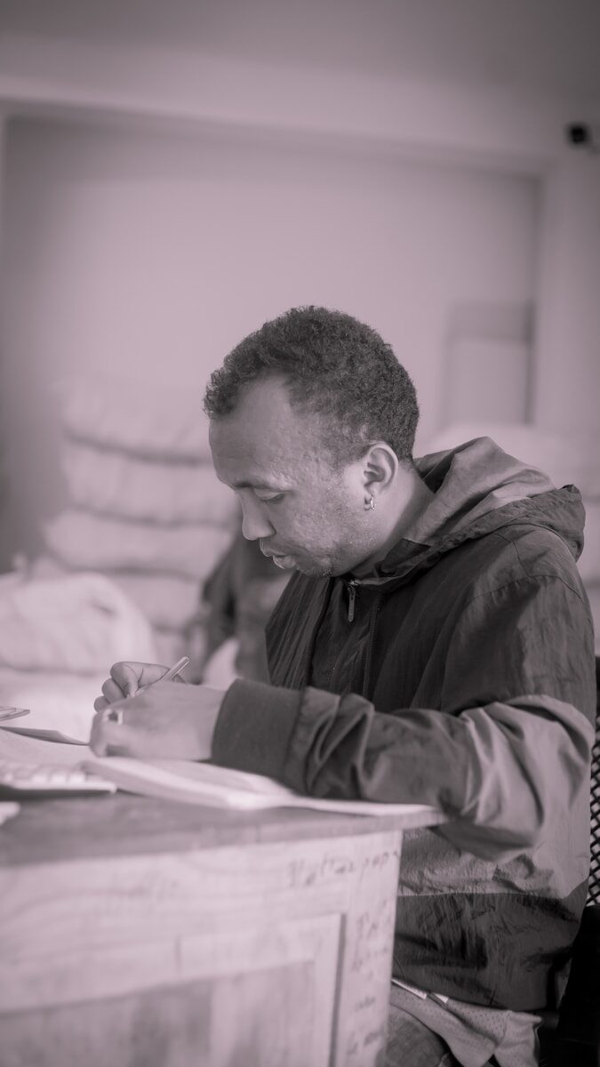 a man sitting at a desk writing on a piece of paper