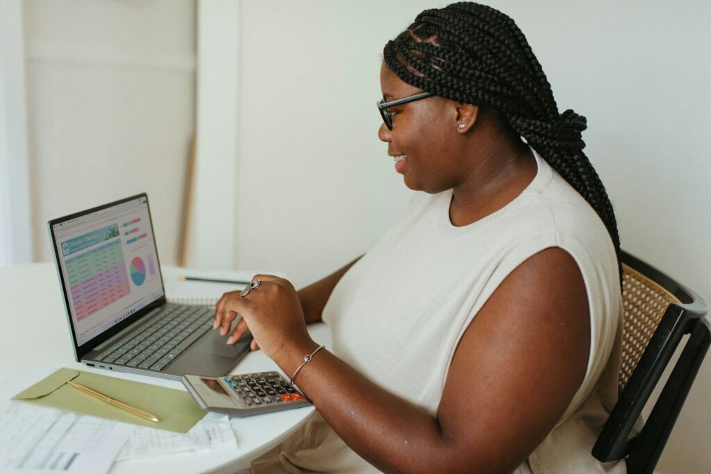 Een persoon zit aan de tafel met een laptop