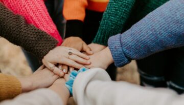 Groep stopt hun handen in gekleurde sweaters