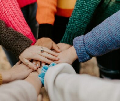 Groep stopt hun handen in gekleurde sweaters